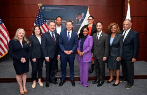 U.S. Transportation Secretary Pete Buttigieg (front middle) announces the new DBE and ACDBE Program Final Rule at USDOT Headquarters in Washington, D.C., on April 9, 2024. (Front row from left) Bridgette Beato, Lumenor Consulting Group; Leslie Richards, SEPTA and Equity Infrastructure Project; Congressman Joaquin Castro (TX), Secretary Buttigieg; Congresswoman Jasmine Crockett (TX) and Congressman Chuy Garcia (IL); Eve Williams, Dikita Enterprises; Bobby Nix, Pleasant News, Inc. (Second row from left) Jude Nix, Pleasant News, Inc.; Irene Marion, USDOT Office of Civil Rights Director.